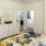 Renovated bedroom featuring white walls, gray pillows, and a floral design blanket
