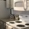 Kitchen room with stove next to refrigerator