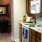 Side view of kitchen area with white stove, microwave, and wooden cabinet